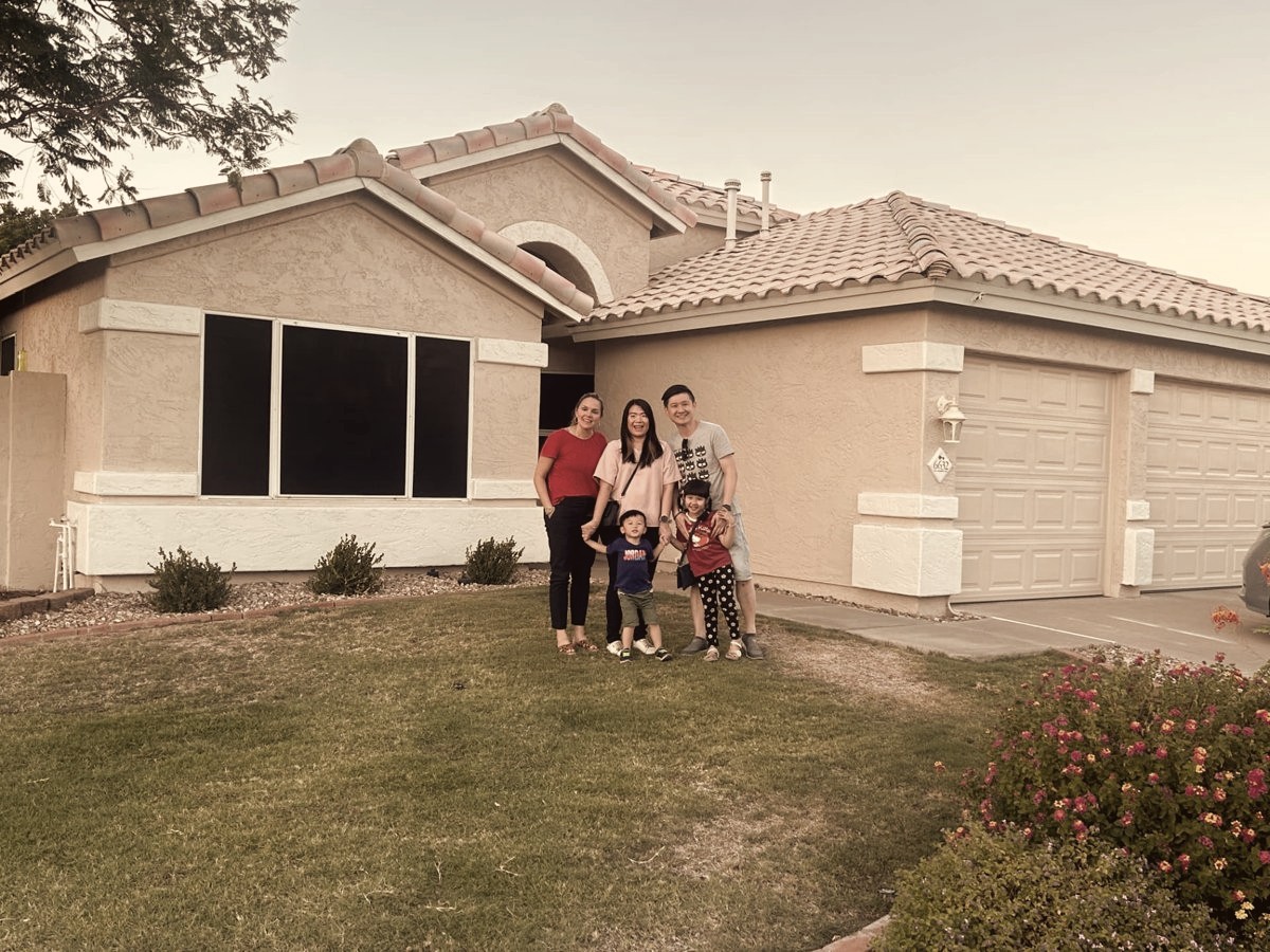 Holly with a family and their two young children on the front lawn of their new Arizona home