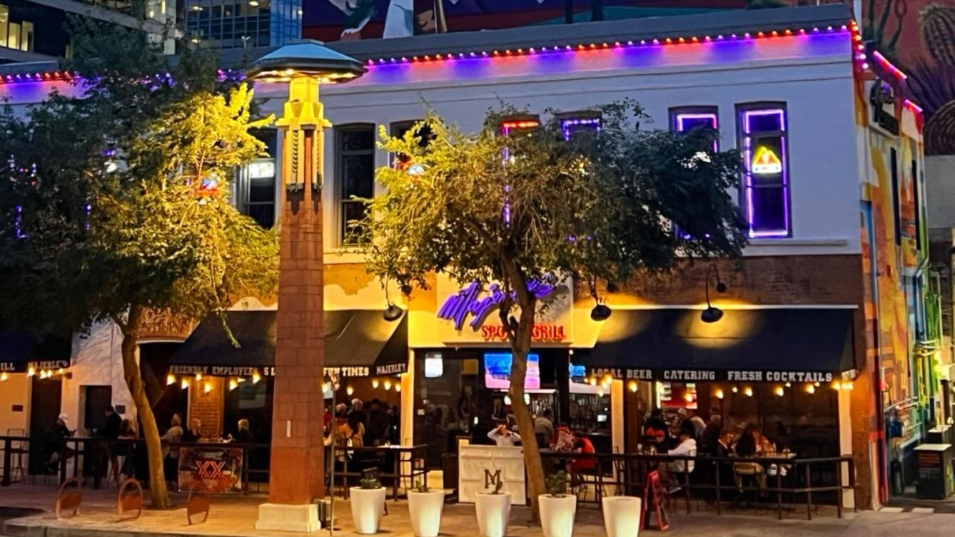 Historic restaurant with a colorful desert mural beneath downtown Phoenix office towers at dusk